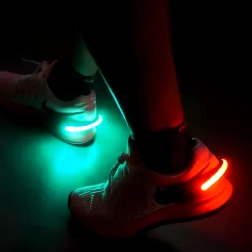 LED-lampa fäst på sko under hundpromenad i mörker