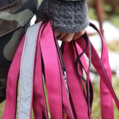 Närbild på hand som håller en rosa spårlina med reflexdetaljer.